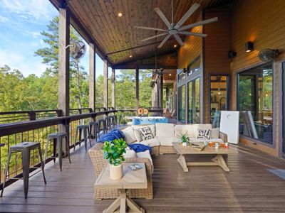 The covered lounge area provides plush, all-season comfort, while the lookout bar running along the deck railing invites guests to sip, snack, and soak in breathtaking panoramic views of the surrounding woods.