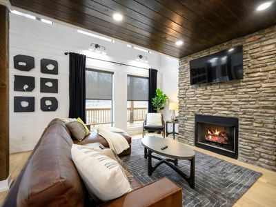 The main living room with a fireplace, tv and leather sectional!