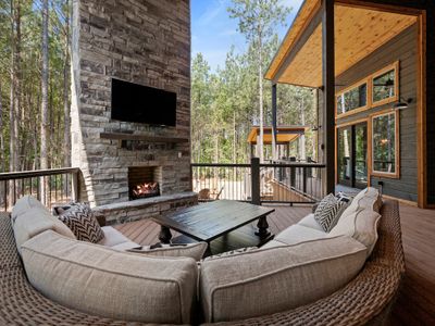 The outdoor patio has an oversized sofa around the fireplace
