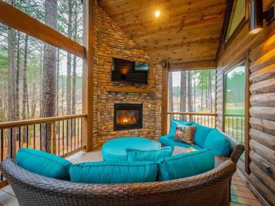 The covered deck with outdoor seating and a fireplace.