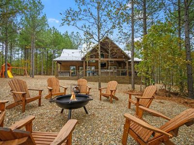 Fire pir with Adirondack chairs surrounding.