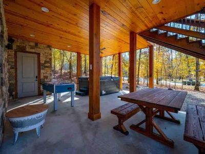 The hot tub, dining table & foosball on the bottom floor of the the outdoor area.