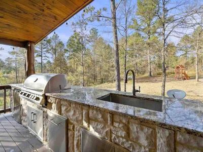 Grill, sink, mini fridge & ample prep-area are available on the covered patio.