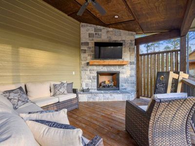An outdoor fireplace surrounded by an oversized sectional on the covered patio!
