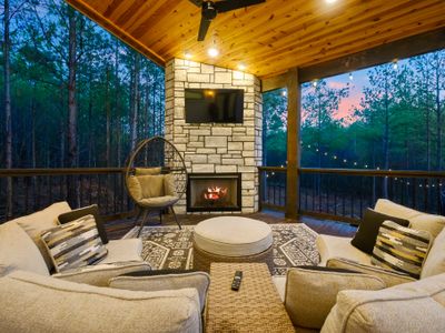 The covered patio houses an oversized outdoor sofa and a gas fireplace.