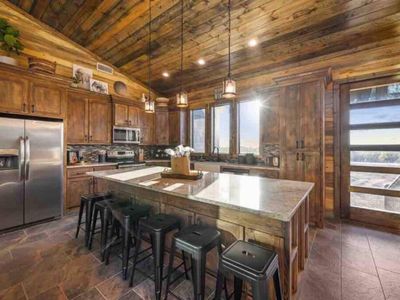 You are seamlessly taken into the kitchen which has 6 bar top seats!