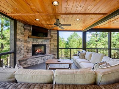 The outdoor covered patio with an oversized outdoor sectional around a fireplace.