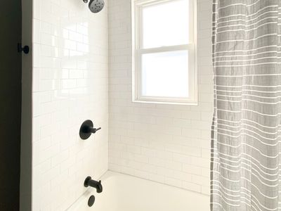 The guest bathroom has a shower and tub set up