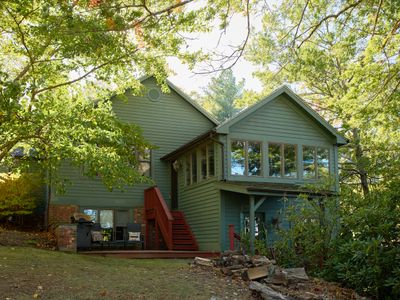 The patio complete with grill, down the steps from the all season room with lake views on every side.