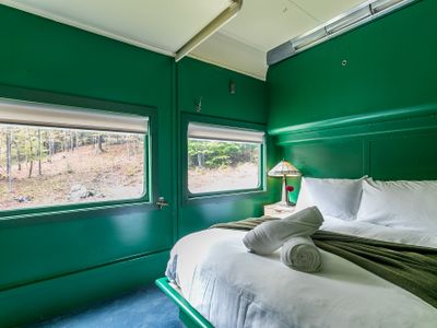 The Adirondack Suite equipped with a closet, bedside table, robes and slippers.