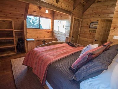 This bedroom comes with bright windows into the outdoors.