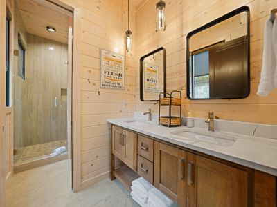 Complete with a stunning tile shower and crisp, luxurious finishes, this ensuite bathroom is a calming retreat where clean lines meet rustic elegance!
