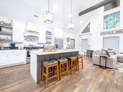 The kitchen with 4 stools at the island.