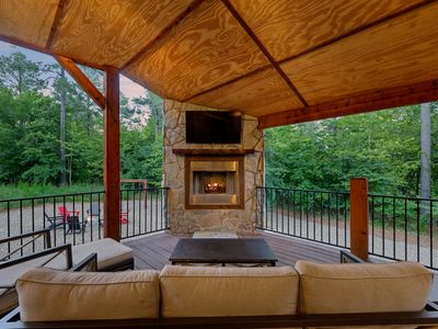The covered outdoor patio on the main level. Outdoor seating around a fireplace.