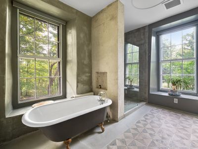 A clawfoot tub set amongst cement is one of many stylish juxtapositions throughout the house.