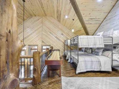 The upstairs loft offers additional sleeping space w/ 4 Queen beds, bunk style.