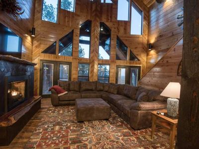 The main living room has an oversized sectional around the tv and fireplace.