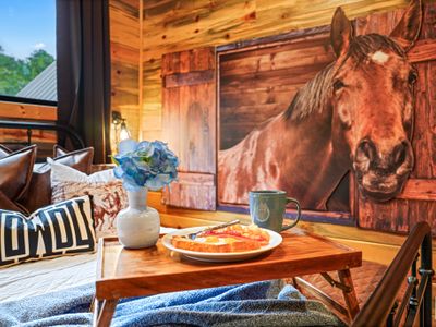 Soft linens, warm woods, and striking horse art create a cozy, unforgettable escape.