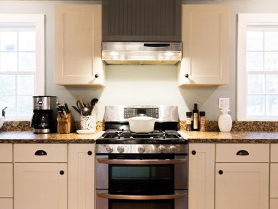 The kitchen includes stainless steel appliances such as a gas stove and double oven as well as a dishwasher, microwave, toaster oven and more.