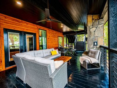 An oversized outdoor sectional and lounge seating is found on the covered patio