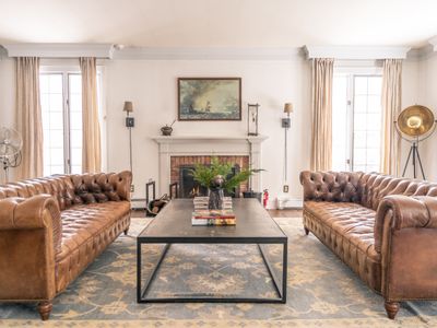 Plenty of seating beside the elegant brick fireplace.