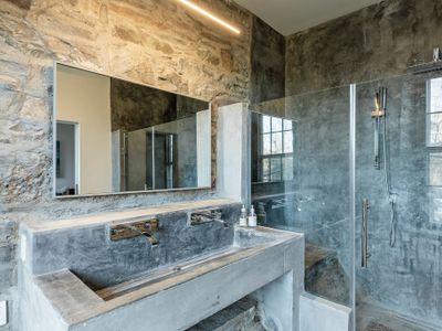 Delight in the rain shower, surrounded by natural stone.