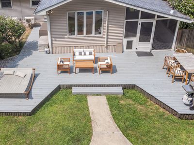 A spacious back deck overlooking the in-ground pool, perfectly designed for those who enjoy grilling, sunbathing, and lounging outdoors.