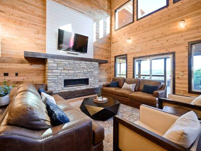 The living room has lounge seating around the stone fireplace.
