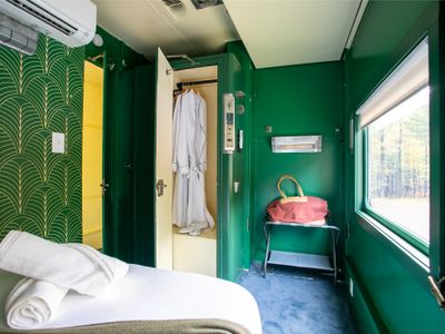 The Adirondack Suite equipped with a closet, bedside table, robes and slippers.