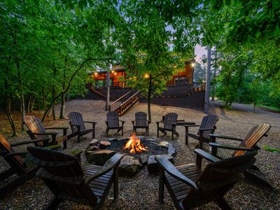 The fire pit in the back yard surrounded by Adirondack chairs.