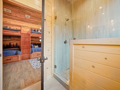 Every shower feels luxurious thanks to the gorgeous tile, soft lighting, and warm wood finishes.