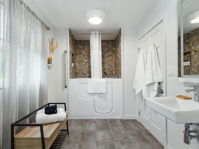 Main level bathroom with shower & handicap bathtub combo.