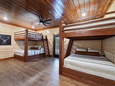 The bunk room has 4 queen beds as well as outdoor access.