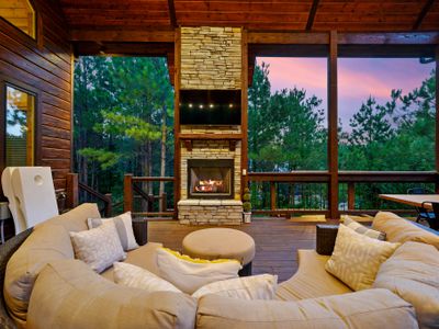 The covered deck has a large sectional around the fireplace and tv!