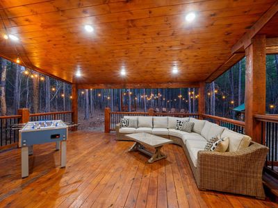 The covered outdoor patio has an oversized outdoor sectional and foosball.