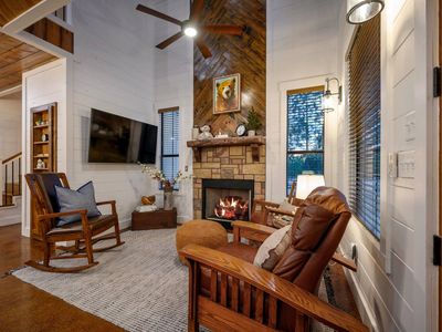 The living room has a stone fireplace at the heart of it.