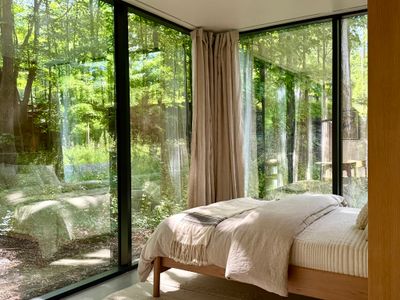 A cozy, upscale sanctuary featuring a plush queen bed and unparalleled, panoramic woodland views.