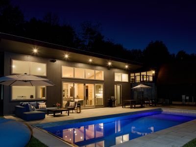 The pool house in the evening, with the second story guest house just beyond.