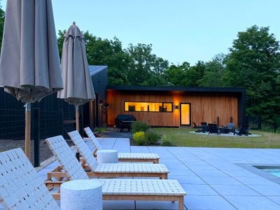 Settle into the loungers as twilight sets in and the home glows warm behind you.