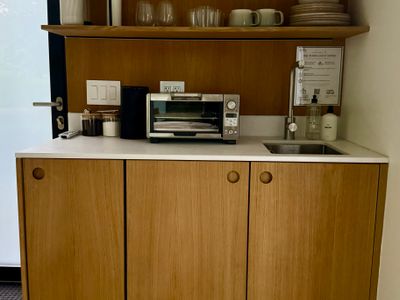 The guest house kitchenette, compact and fully appointed in white oak.