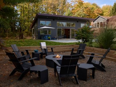 The propane fire pit, with pool deck and pool house in the background.