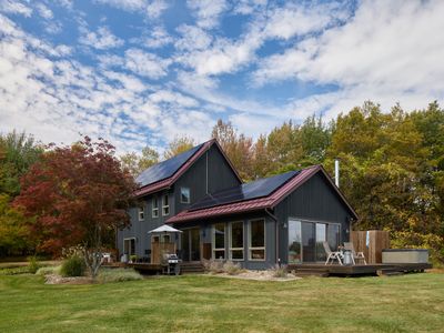 Looking towards the main house and hot tub deck. Oversized windows and sliding glass doors create beautiful views on the interior and fill the space with light.