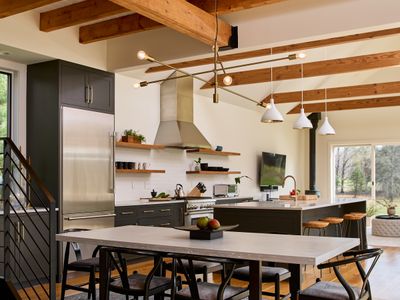 The chef's kitchen and dining area in the main house, with the living room and entry to the hot tub deck beyond.