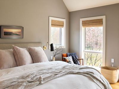 The primary bedroom in the main house, with views of the pool and private meadow.