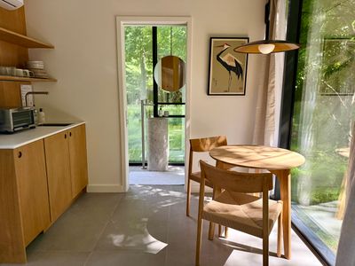 Sunlit dining nook with a round oak table and a signature heron print.
