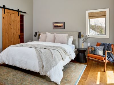 Upstairs in the main house, the primary bedroom features a king bed, soaring ceilings, walk-in closet and ensuite bath.