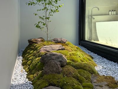A serene moss-and-stone garden brings nature right up to the bath.