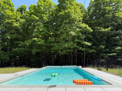 Cool off in the private pool, tucked against a backdrop of lush summer forest.