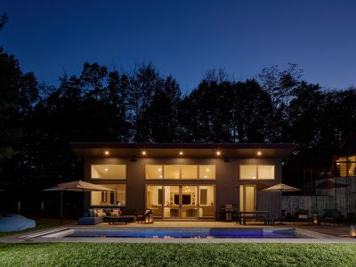 A shot of the pool house at night, which looks out onto five private acres.