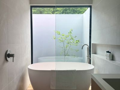 Soak in the spa-inspired bath, where a freestanding tub frames a private garden view.